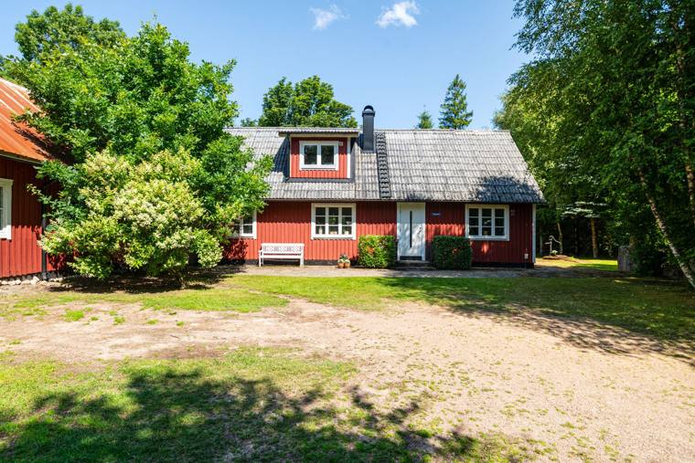 Husets framsida: rött trä, vita fönster och takkupa